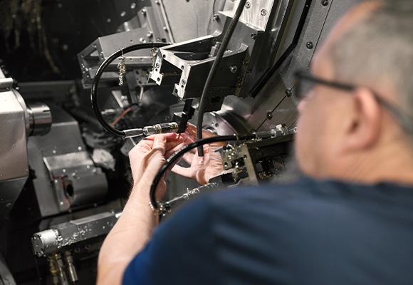 Detailaufnahme von Mitarbeiter bei Maschine